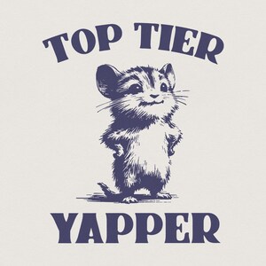 May include: A navy blue graphic featuring a smiling mouse with its paws on its hips. The text "TOP TIER" arches above the mouse, and "YAPPER" is below. The design has a vintage, sketched aesthetic.
