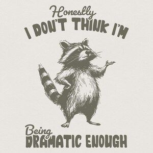 Puede incluir: Una ilustración gráfica de un mapache de pie sobre sus patas traseras con una mano gesticulando hacia afuera. El texto de arriba dice Honestly I DON'T THINK I'M y el texto de abajo dice Being DRAMATIC ENOUGH. Diseño gris oscuro sobre fondo claro.