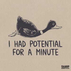 Puede incluir: Ilustración en blanco y negro de un pato en posición prona. El texto dice "I HAD POTENTIAL FOR A MINUTE" en una fuente de estilo manuscrito. El fondo es de color beige claro.