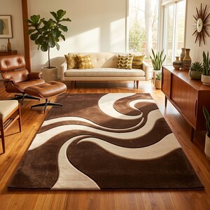 May include: A brown and cream-colored area rug with a swirling, abstract design. The rug is rectangular and features a plush texture. The color palette includes shades of brown and cream, creating a modern, stylish look. The rug is placed in a living room setting.