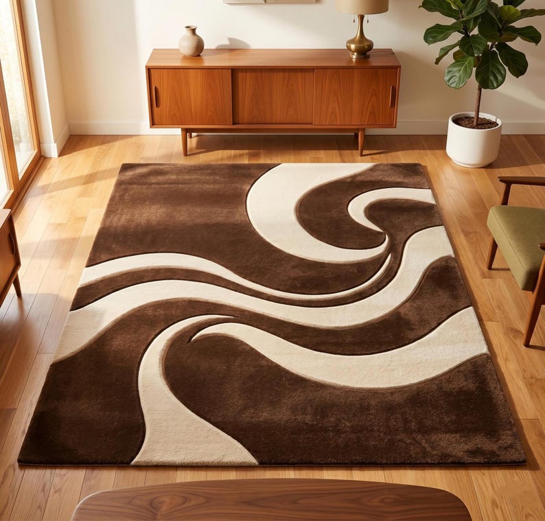 Top-down view of a hand-tufted fine premium wool rug by SHAH RUGS. The modern abstract design features bold, flowing 3D carved waves in a contrasting two-tone palette of deep chocolate brown and creamy beige. Styled flat against a clean white background.