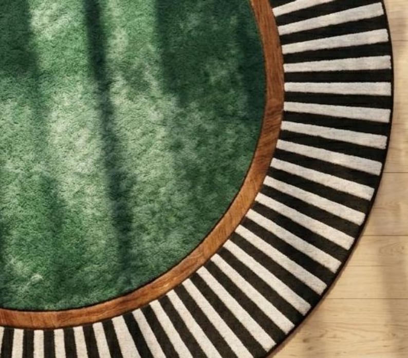 Puede incluir: Una alfombra redonda con un centro verde, un borde marr&oacute;n y un borde exterior a rayas blancas y negras. El dise&ntilde;o de la alfombra presenta una combinaci&oacute;n de texturas y patrones, creando un revestimiento de suelo visualmente atractivo.