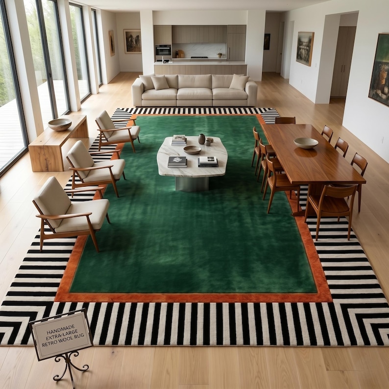 Puede incluir: Un interior de sal&oacute;n moderno con una gran alfombra verde con borde naranja, rodeada por una alfombra a rayas blancas y negras. La habitaci&oacute;n incluye un sof&aacute;, sillas, una mesa de centro y una mesa de comedor.