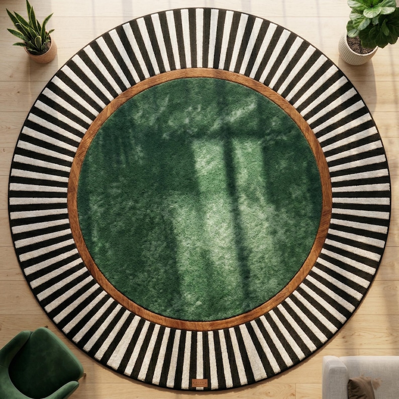 Puede incluir: Alfombra redonda con centro verde, borde marr&oacute;n y borde exterior a rayas blancas y negras. La alfombra est&aacute; colocada sobre un suelo de madera clara. Se ven plantas en macetas a ambos lados de la alfombra.