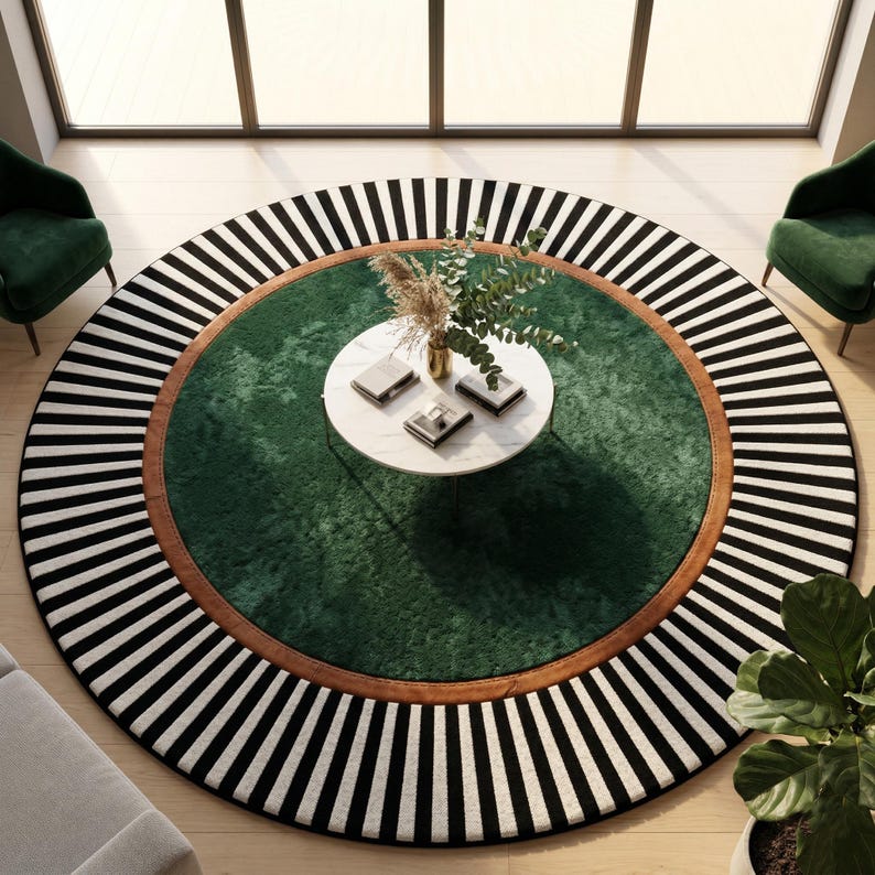 Puede incluir: Una alfombra redonda con un centro verde, un borde marr&oacute;n y un borde exterior a rayas blancas y negras. Una peque&ntilde;a mesa blanca con libros y un jarr&oacute;n con flores secas se encuentra en el centro de la alfombra. Se ven dos sillas verdes.