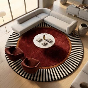 Puede incluir: Vista a&eacute;rea de un sal&oacute;n moderno con una alfombra grande y redonda. La alfombra tiene un centro rojo oscuro, un borde marr&oacute;n y un borde exterior a rayas blancas y negras. Dos sillones burdeos frente a una mesa de centro blanca.