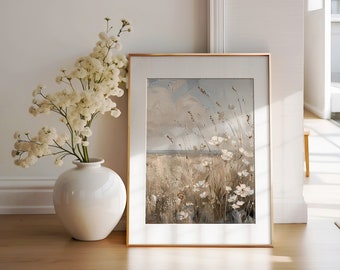 May include: A framed painting depicting a field of white wildflowers against a blue sky with clouds. The painting is in a gold frame and is hanging on a white wall.