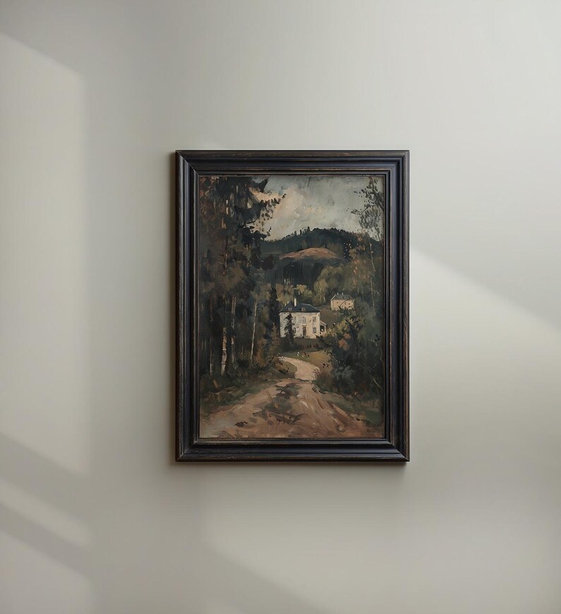 May include: Framed landscape painting depicting a dirt road leading to a white house nestled among trees. The artwork features a dark wooden frame and a muted color palette of greens, browns, and grays, evoking a serene, natural scene.
