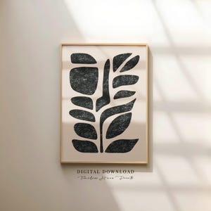 May include: Abstract black and beige art print in a wooden frame. The print features a stylized plant design with textured black shapes against a beige background. The words "DIGITAL DOWNLOAD" and "Timeless Home Prints" are at the bottom.