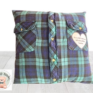 May include: A square throw pillow crafted from a blue and teal plaid flannel shirt. The pillow features a central button-down placket, two chest pockets, and a heart-shaped patch on the right pocket with the text: This is a shirt I used to wear, hold it close and know I am here.