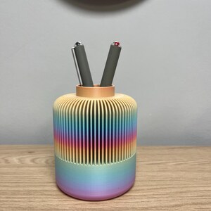 Peut inclure: Ensemble de trois mugs en céramique avec une finition mate et mouchetée. Les tasses sont dans les tons crème, gris clair et gris foncé. Chaque mug a un design simple et minimaliste, idéal pour le café ou le thé.