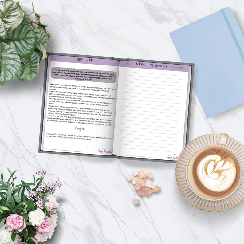 May include: Open journal with a gray cover and white pages. The left page has the title "Set Free" and a quote about letting go of the past. The right page has the title "New Beginnings" and is blank. The journal is on a white surface with a cup of coffee and pink sugar crystals.