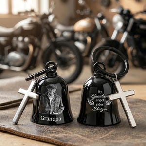 May include: Two black motorcycle bells with silver crosses. One bell has a portrait of a man and the word "Grandpa". The other bell has the text "My Guardian angel rides Shotgun" with angel wings.