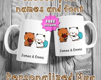 May include: Two white ceramic mugs with cartoon bear illustrations. Each mug features a brown bear and a white bear holding a red heart. The text "James & Emma" is printed below the bears. The image includes the text "Choose your names and font" and "Personalized Mug".