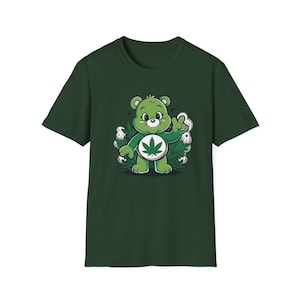 May include: Dark green t-shirt featuring a cartoon bear with a cannabis leaf on its belly. The bear is green with a white belly and is surrounded by cannabis leaves and smoke. The bear is giving a peace sign.