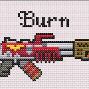 May include: A red and grey toy gun with a yellow eagle emblem and a gold and brown magazine. The gun is labelled "Burt".