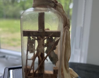This item is a vintage folk art "Crucifixion Bottle" or Geduldflasche, a type of bottle whimsy depicting the passion of Christ. 