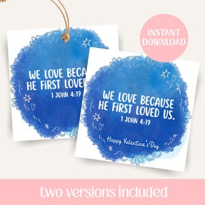 May include: Two white cards with blue watercolour designs and the text "WE LOVE BECAUSE HE FIRST LOVED US. 1 JOHN 4:19". One card has a string attached. The other card says "Happy Valentine's Day". A pink circle says "INSTANT DOWNLOAD".