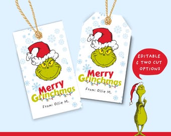 May include: Two white gift tags with the Grinch's face wearing a Santa hat and the text "Merry Grinchmas". The tags have a string for hanging and snowflake accents. The text "From: Ollie M." is also included.