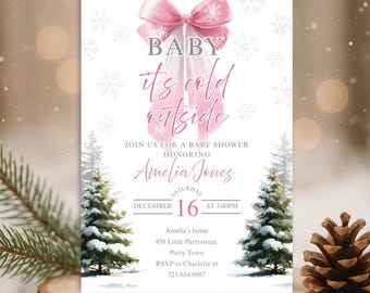 Puede incluir: Una invitación a un baby shower con temática invernal. La invitación presenta un lazo rosa y el texto "BABY it's cold outside". La invitación también incluye el nombre "Amelia Jones", la fecha, la hora y la información de RSVP.