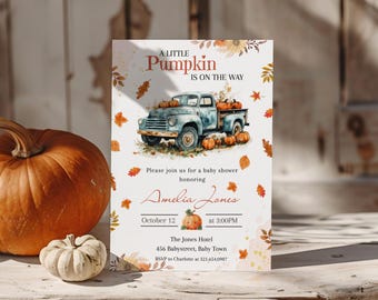 Op de afbeelding: Een uitnodiging voor een babyshower met een aquarel illustratie van een vintage blauwe vrachtwagen met pompoenen. De tekst luidt "A Little Pumpkin Is On The Way" en nodigt gasten uit om Amelia Jones op 12 oktober te vieren.