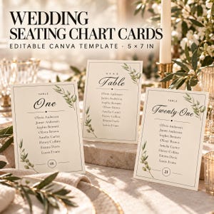 May include: Three rectangular wedding seating chart cards measuring 12.7 by 17.8 cm, featuring a cream background, black serif and script text, and green olive branch illustrations. The cards display table numbers and guest names in a list format.