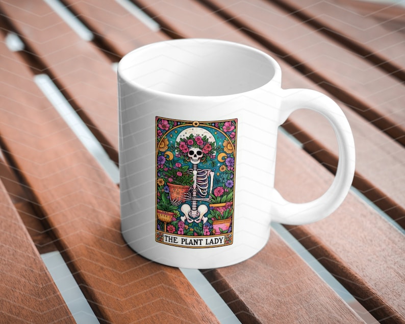 May include: White ceramic mug featuring a colourful illustration of a skeleton holding plants. The illustration is framed with a decorative border and the text "The Plant Lady" is at the bottom.