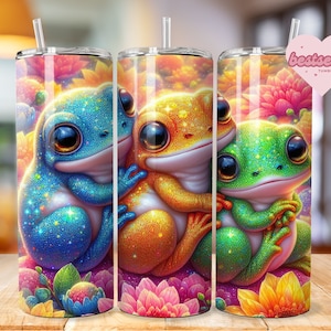 May include: Three colorful glitter frog illustrations on a tumbler wrap. The frogs are hugging each other and are surrounded by flowers. The frogs are blue, yellow, and green.
