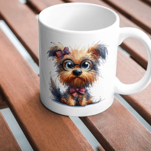 May include: White ceramic mug with a cartoon illustration of a Yorkshire Terrier wearing glasses and a bow tie. The dog has brown and black fur and a pink bow in its hair.