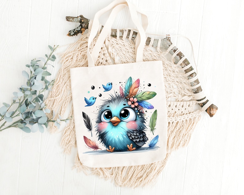 Puede incluir: Una bolsa de tela blanca con un p&aacute;jaro azul que lleva un tocado de plumas de colores. El p&aacute;jaro tiene ojos grandes y un rubor rosado. Dos p&aacute;jaros azules m&aacute;s peque&ntilde;os vuelan detr&aacute;s del p&aacute;jaro principal.