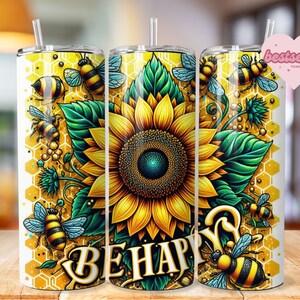 Puede incluir: Un vaso blanco con un diseño de girasol amarillo y verde, abejas y un patrón de panal. El texto "BE HAPPY" está escrito en una fuente amarilla de estilo manuscrito.