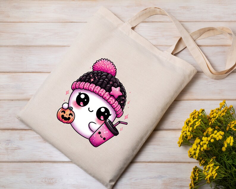 Peut inclure: Un sac en toile blanc avec un fant&ocirc;me de dessin anim&eacute; rose et noir portant un chapeau rose et noir, tenant une citrouille et une tasse rose avec une paille. Le fant&ocirc;me a de grands yeux et un sourire mignon.