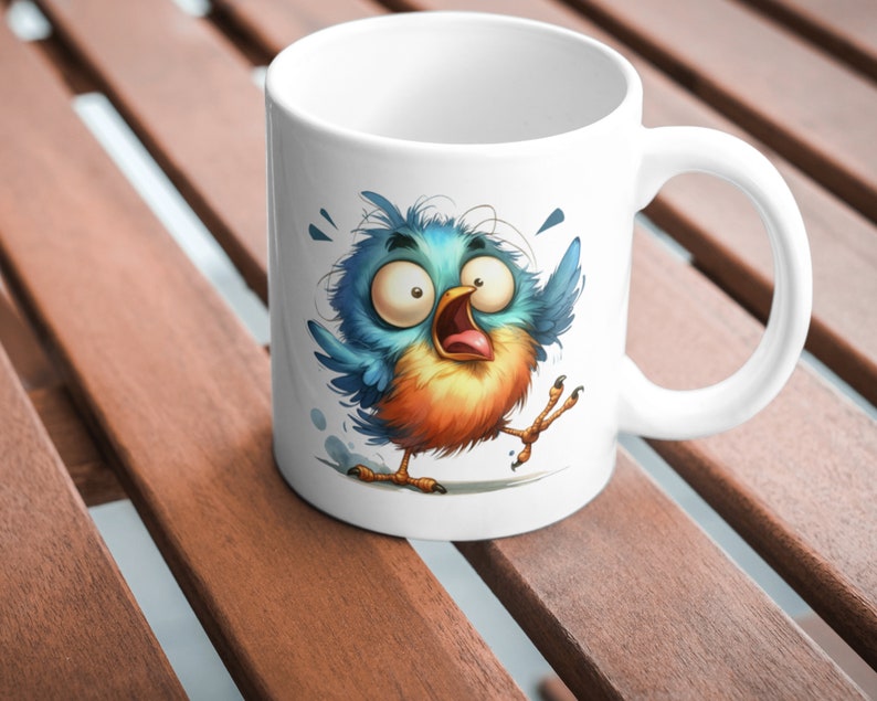 Puede incluir: Taza de cer&aacute;mica blanca con una ilustraci&oacute;n de dibujos animados de un p&aacute;jaro azul y naranja con ojos grandes y el pico abierto. El p&aacute;jaro est&aacute; representado en una pose asustada con las alas extendidas.