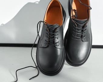 光沢のあるレザーミックスを使用した女性用の象徴的なブラックの