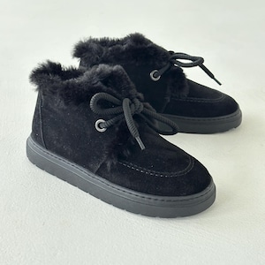 Puede incluir: Botines de ante negro con ribete de piel sintética. Los botines tienen punta redonda, cierre de cordones y suela gruesa de goma negra. Diseñados para climas fríos y uso casual.