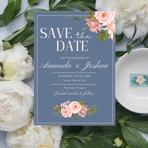 May include: A blue save the date card with white text and pink floral illustrations. The text reads "Save the Date" for the wedding of Amanda & Joshua, Saturday 7th of June, Twenty Twenty Four, Portland, Oregon, formal invite to follow.