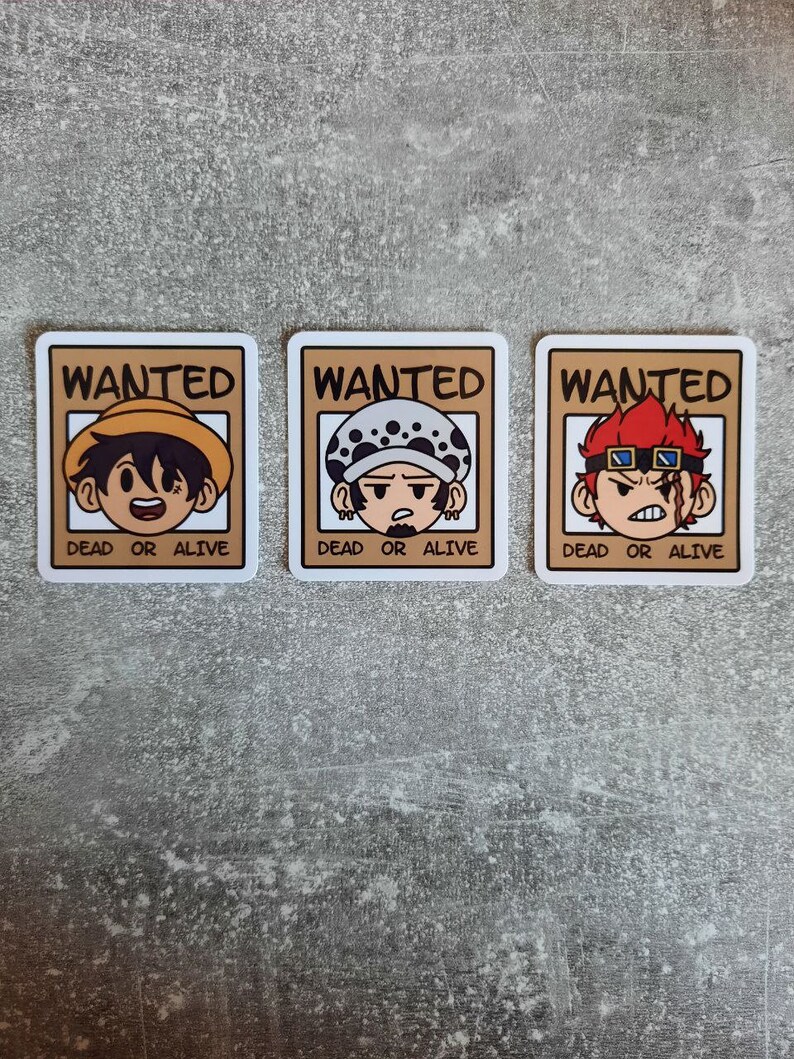 May include: Three wanted posters with cartoon characters. Each poster has the word "WANTED" at the top and "DEAD OR ALIVE" at the bottom. The first poster features a character with brown hair and a straw hat. The second poster features a character with a white and black bandana and a black eye patch. The third poster features a character with red hair and red goggles.