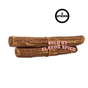 May include: Two brown sticks tied together with twine. The sticks have a textured surface. A black circle with the text "2 STICKS" is in the upper right corner. The text "SOLD BY FLAVOR SPICE" is printed on the sticks.