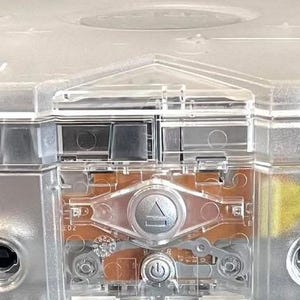 May include: A transparent Xbox console, showcasing internal components. The console has the word "XBOX" on the front. It features multiple ports and a power button. The clear casing allows a view of the internal hardware.