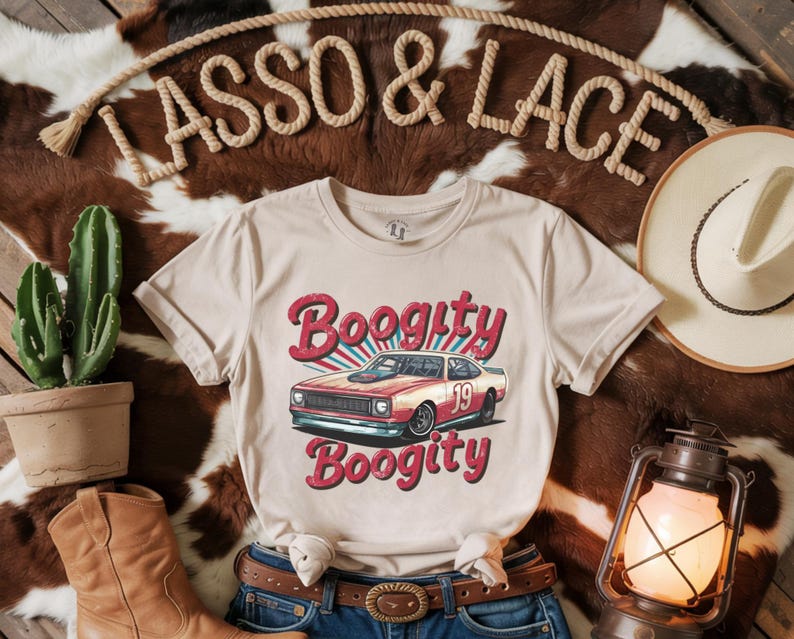 以下が含まれることがあります： ベージュのTシャツに、赤いレーシングカーのレトロなグラフィックがプリントされています。赤い文字で「Boogitty」と書いてあり、車の側面には「19」の数字が書かれています。