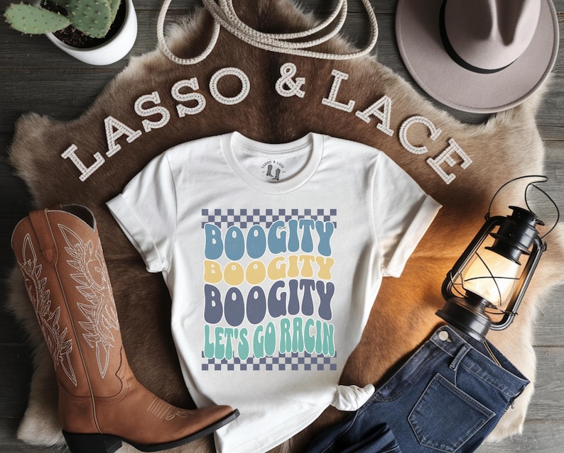 May include: White t-shirt with a checkered background and the text "Boogit Boogit Boogit Let's Go Rac'n" in a retro font. The text is in shades of blue, yellow, and green.