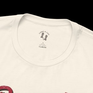 以下が含まれることがあります： 白地に、カウボーイブーツと「Lasso & Lace」の文字が黒と白で描かれたTシャツ。Tシャツには、「L」と「100% コットン バングラデシュ製」と書かれたサイズタグが付いています。