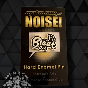 Könnte beinhalten: Goldene Emaille-Anstecknadel mit einer Sprechblase, die in schwarzer Schrift "Bleat" sagt. Die Anstecknadel befindet sich auf einer schwarzen Karte mit goldener Schrift, die "Make Some Noise!" und "Hard Enamel Pin" sagt. Die Karte enthält auch den Text "Entropy's Arts & Primrose Kennel Club".