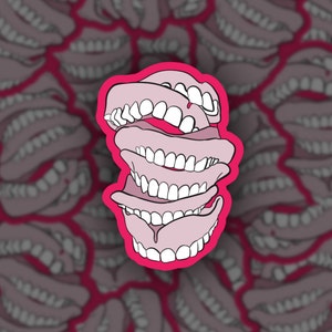Può includere: Una pila di dentiere rosa e bianche su uno sfondo rosa. Le dentiere sono impilate l'una sull'altra, con la dentiera superiore leggermente aperta. Le dentiere sono un simbolo comune dell'invecchiamento e della perdita dei denti.