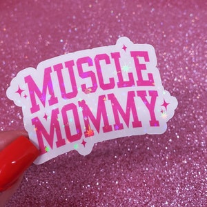 May include: A white sticker with pink lettering that reads "MUSCLE MOMMY" with iridescent glitter accents.