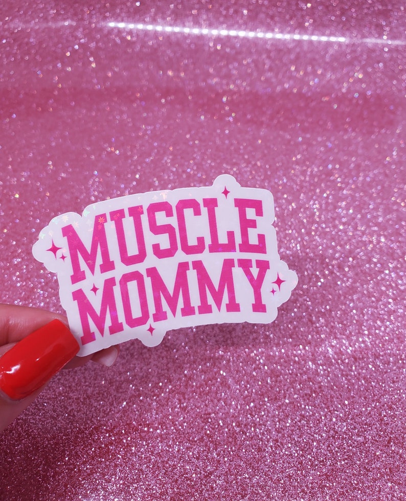 May include: A white sticker with pink lettering that reads "MUSCLE MOMMY" with glitter accents.
