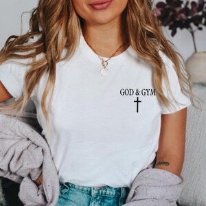 May include: White t-shirt with the text "GOD & GYM" and a small black cross below it.