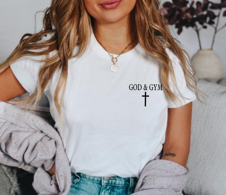May include: White t-shirt with the text "GOD & GYM" and a small black cross below it.