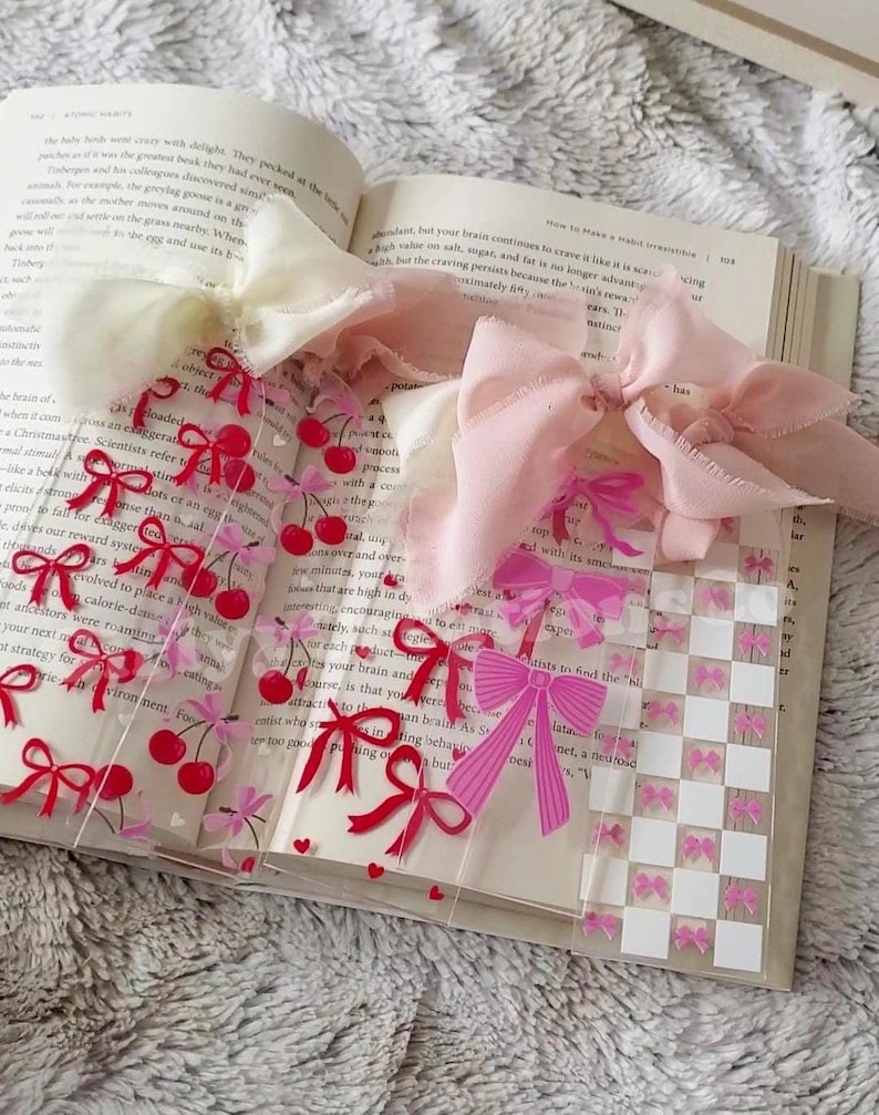 Pu&ograve; includere: Tre segnalibri in acrilico trasparente con fiocchi rosa e rossi e ciliegie. I segnalibri hanno un motivo a scacchi sul retro.