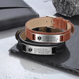 Puede incluir: Dos pulseras de alerta m&eacute;dica de cuero con placas de acero inoxidable. La pulsera superior es de cuero marr&oacute;n con una placa plateada que dice "ALLERGIC TO ALL ALLERGIC TO SULFA ICE: 348-514-2299". La pulsera inferior es de cuero negro con una placa plateada que dice "ALLERGIC TO ALL ALLERGIC TO SULFA ICE: 348-514-2299".